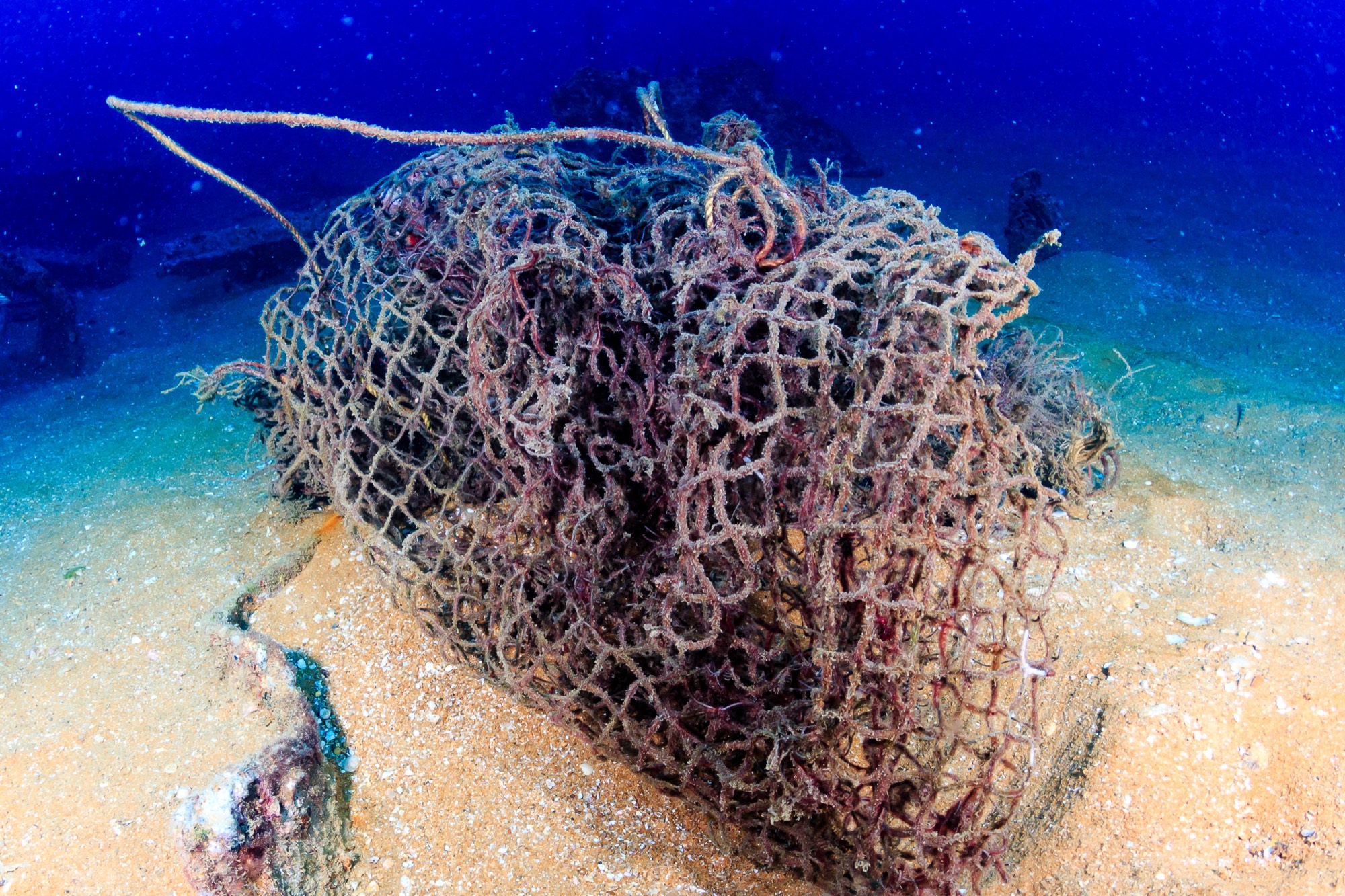 A discarded fishing net lying on the seabed